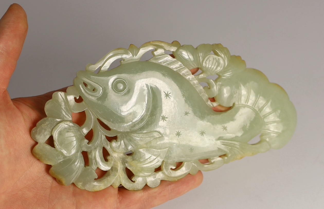 A Chinese pale celadon jade 'fish' plaque, 18th/19th century, 16.7cm long, 8.5cm high, later wood stand for use as a table screen